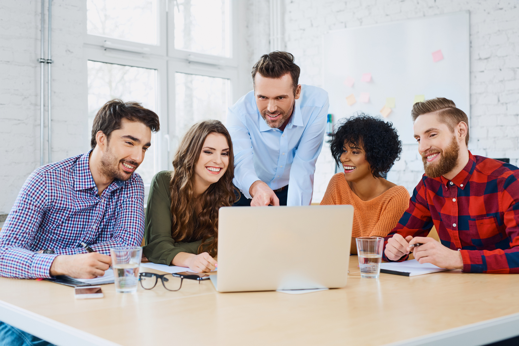 Creative agency coworkers discussing new project on laptop